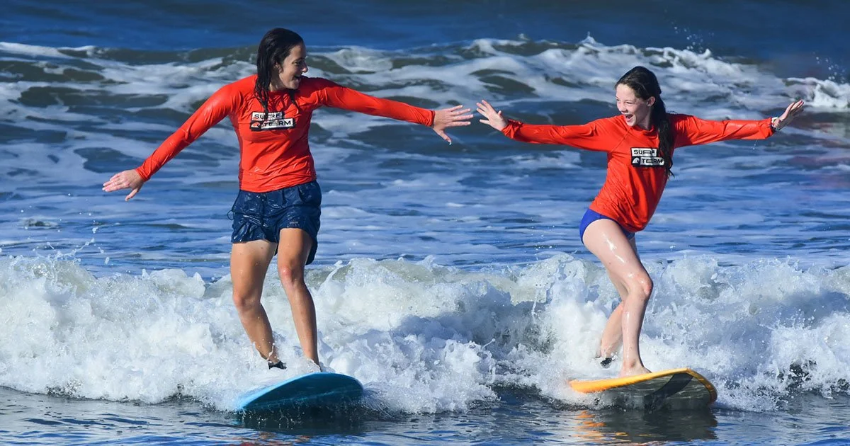 Two teens surfing side by side during Discover Term