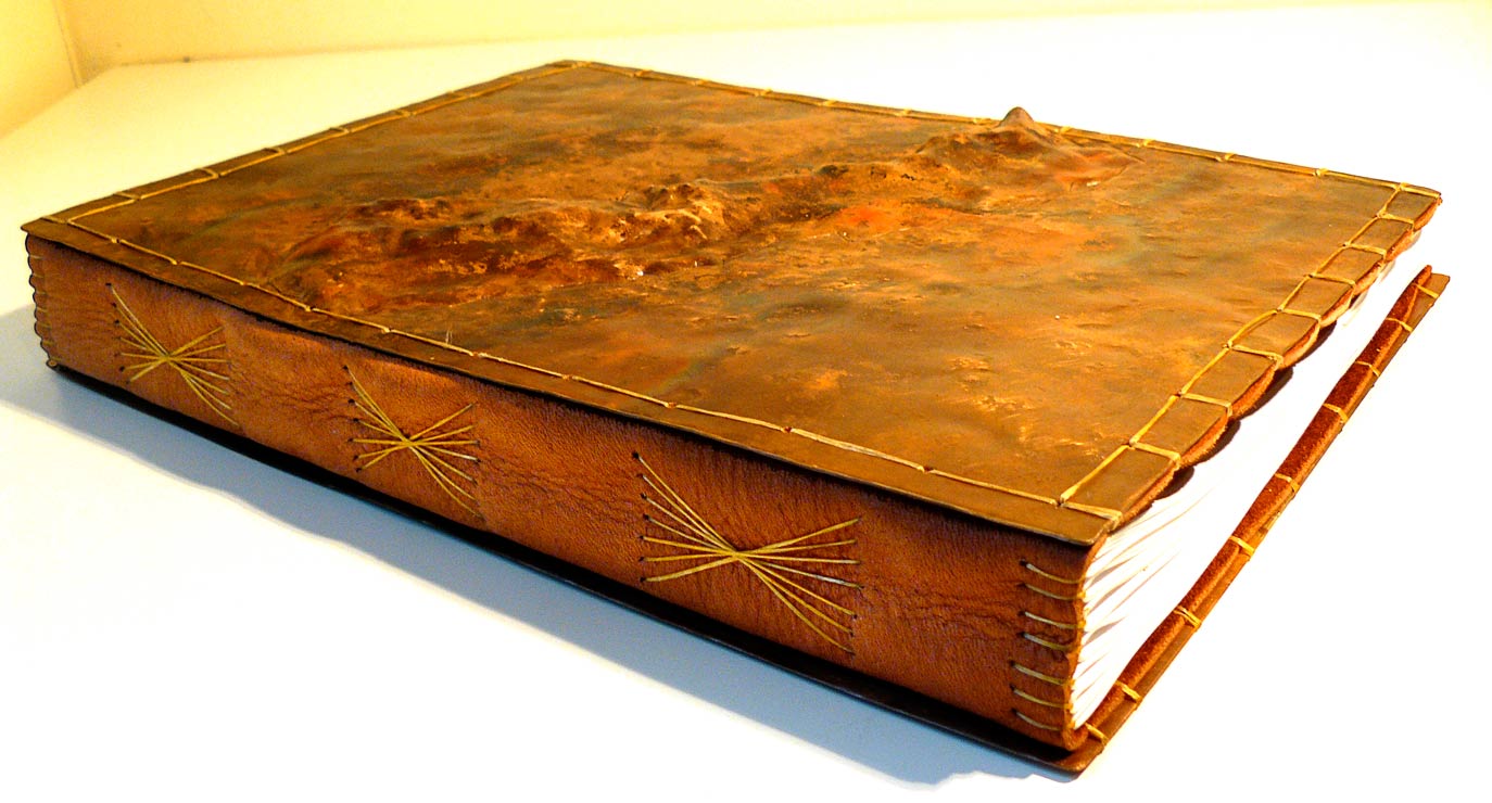   detail, hand-bound, leather and repouss&eacute;'d copper  