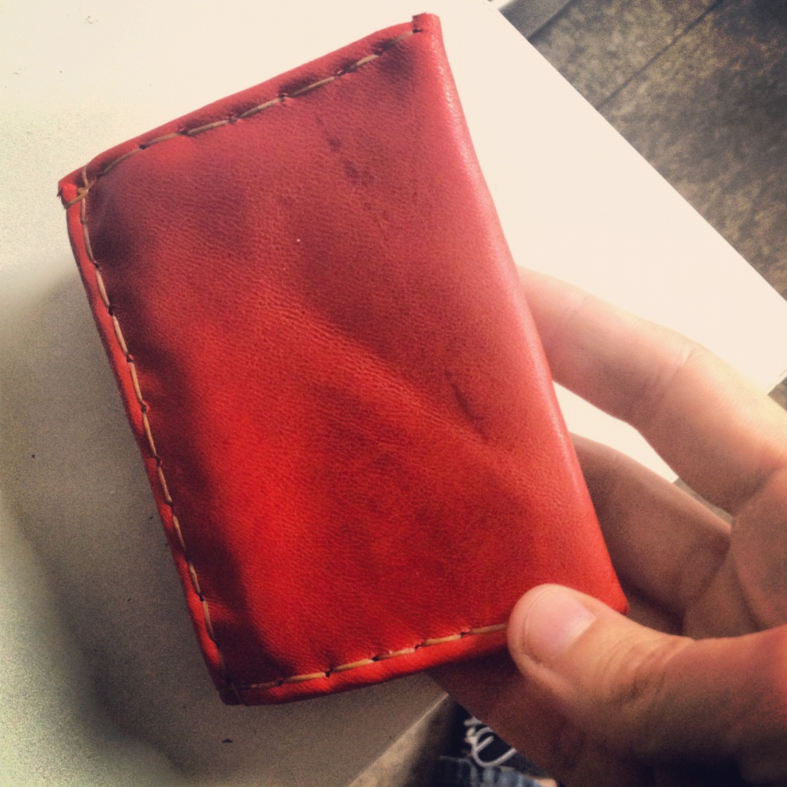hand-sewn leather wallet, from one piece of leather, folded, with sinew thread