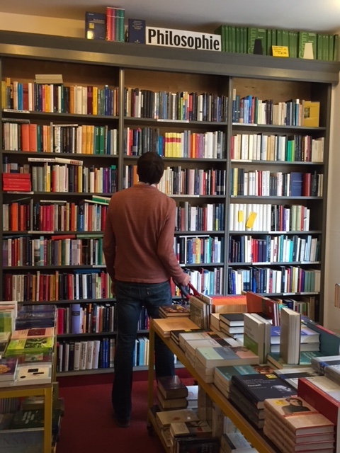 Christopher perusing the "Philosophie" section of a used book store in Berlin.