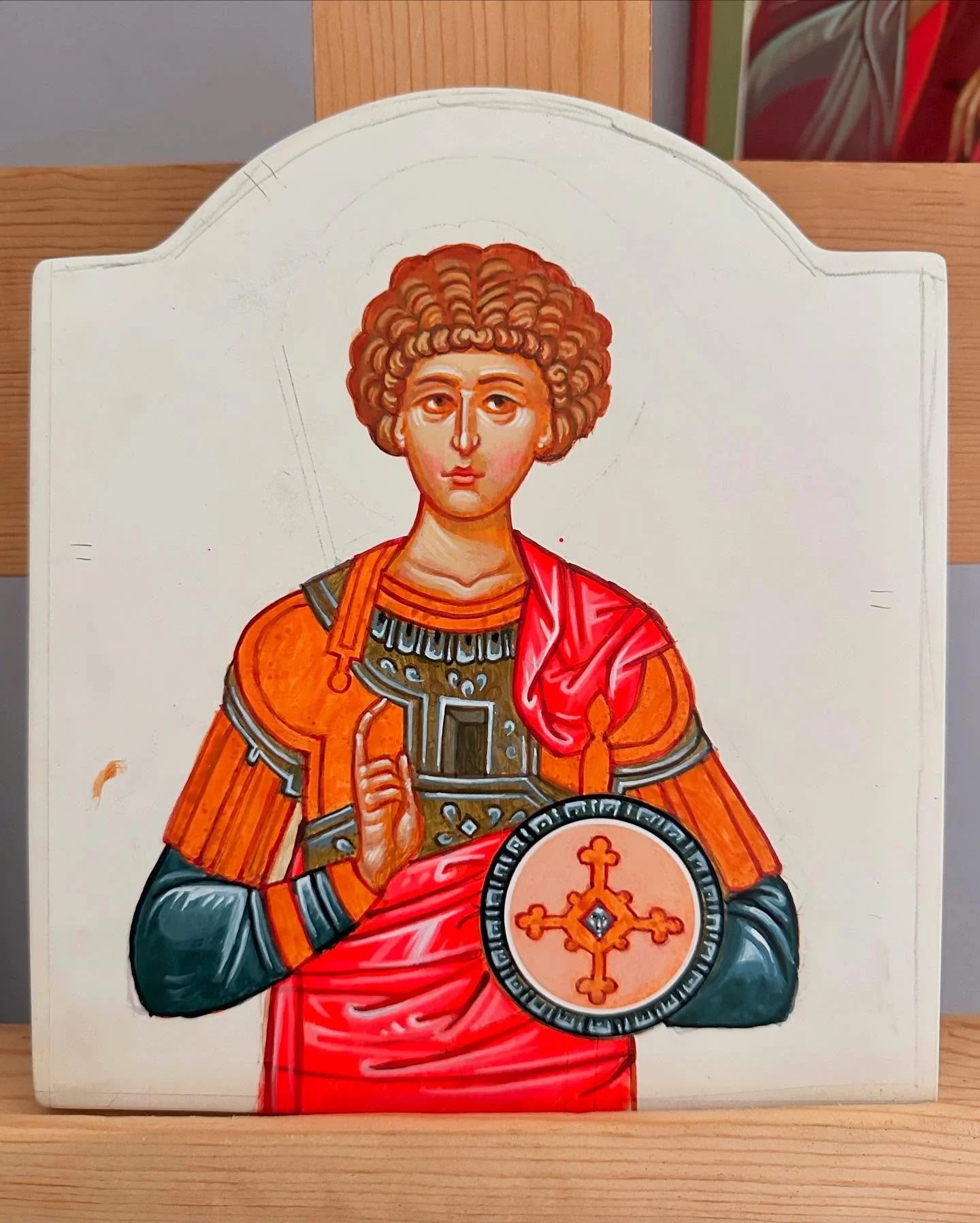 Saint George Icon prior to gilding.
This icon has taken many quiet hours while the glaze layers were building up the shape with terra verde technique. 
The garments are finished, the hand is raised in blessing, and now the face has arrived.
For me, t
