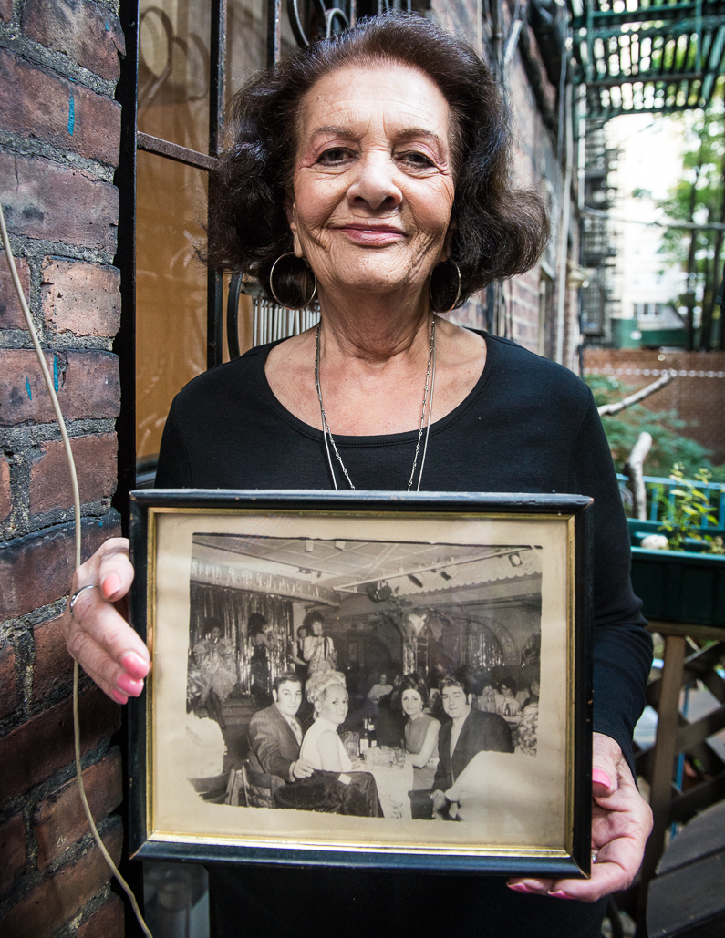 Arlene with a photo of her, her husband and friends