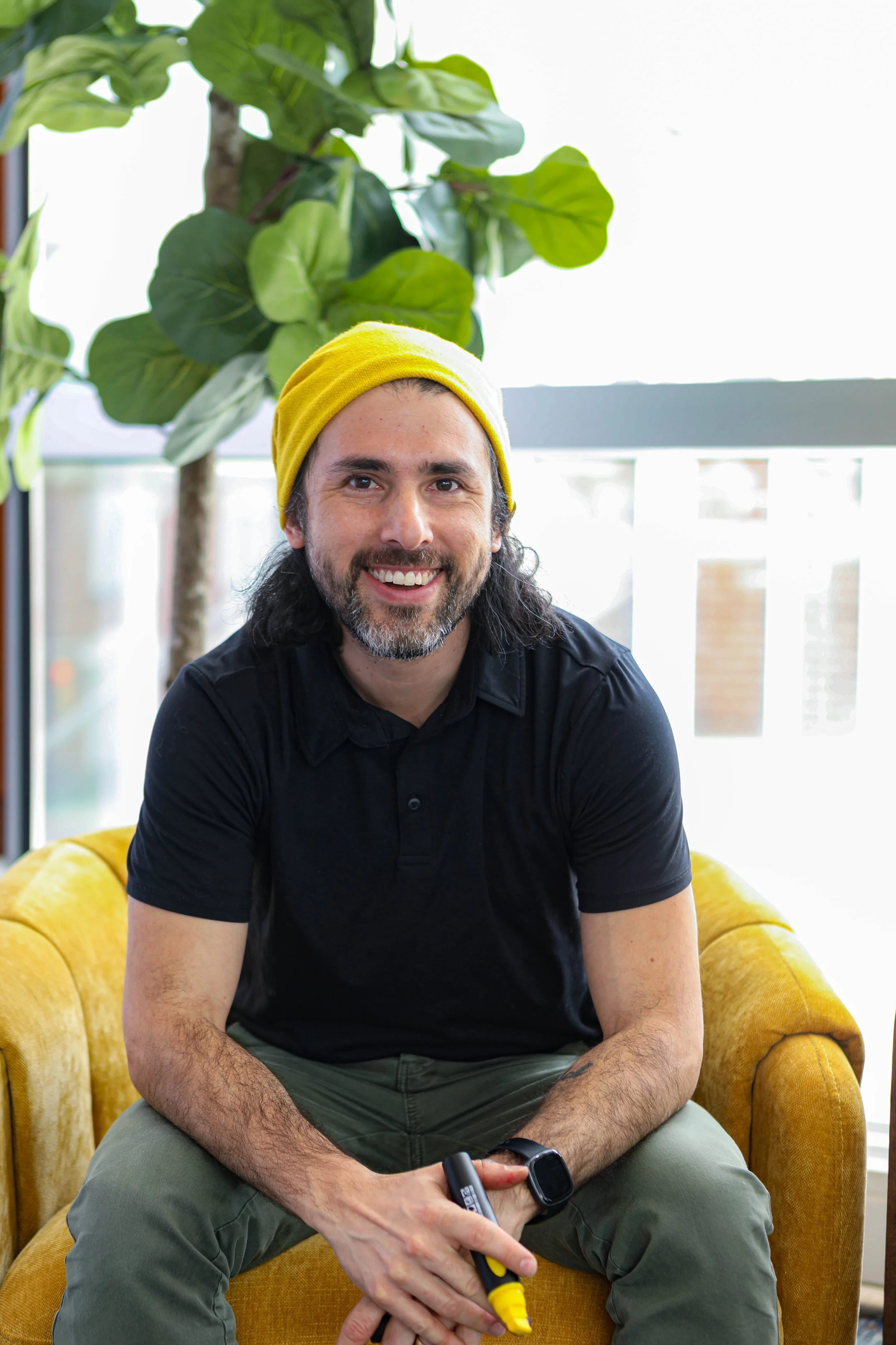 Alejo Porras smiling at the camera while holding a yellow marker