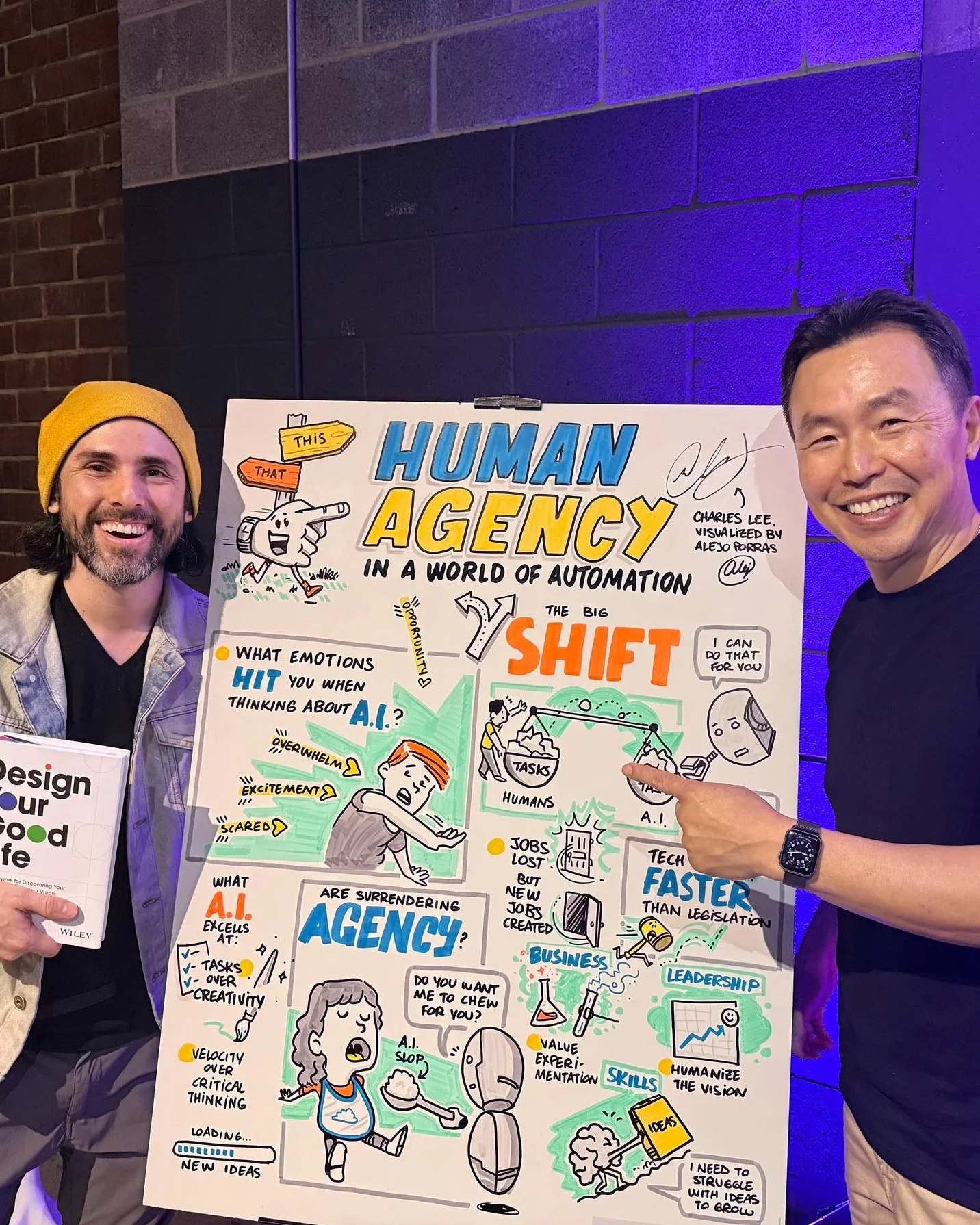 Alejo and Charles T. Lee pose in front of the graphic recording board Alejo created of Charles' keynote at Plywood Place.