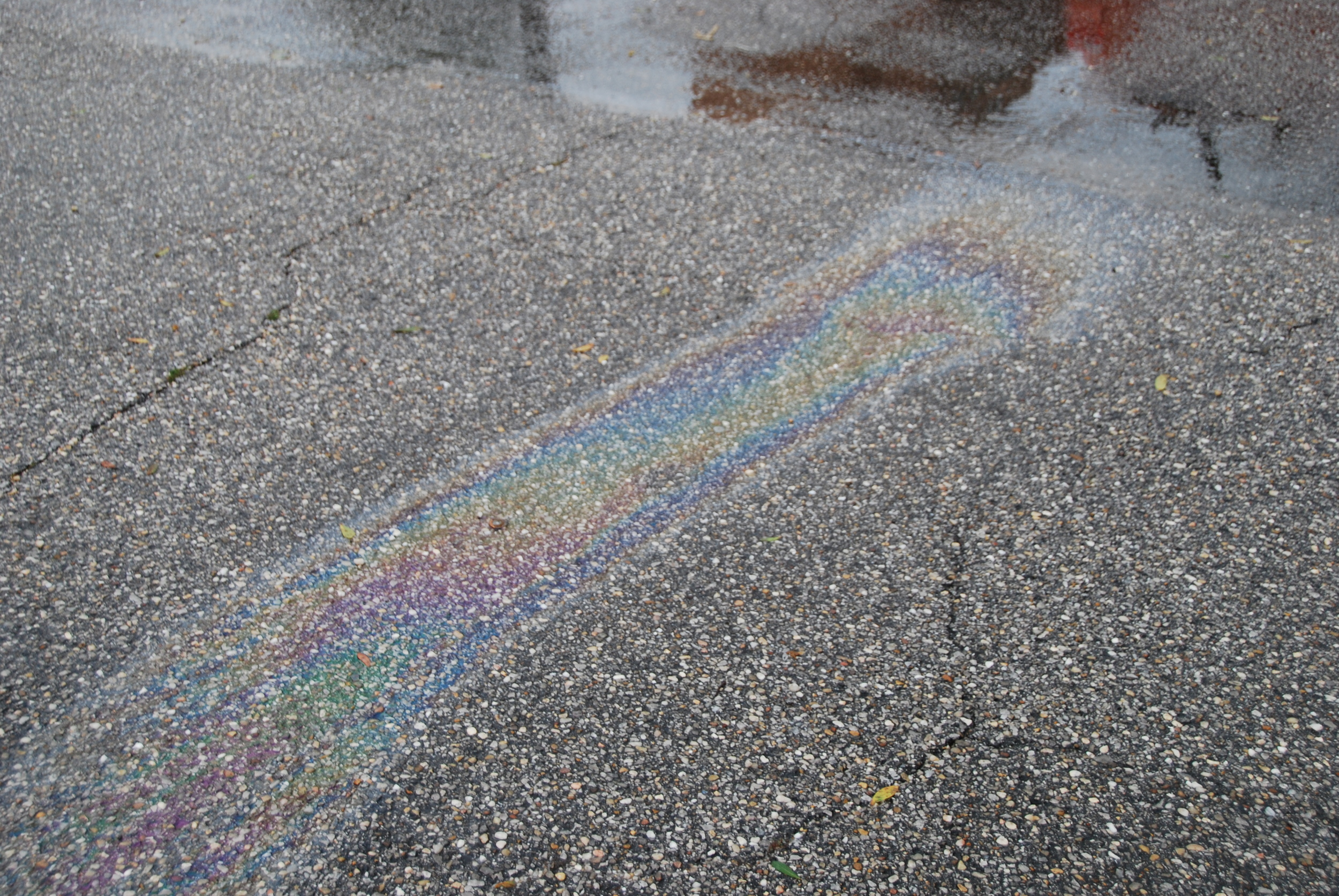 After a rainstorm an oil sheen forms on a parking lot in Baldwin County where a car was leaking oil.