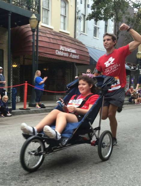 Wade Stoudenmire pushes Captain Grace Green to the finish line in the Senior Bowl 10K. 
