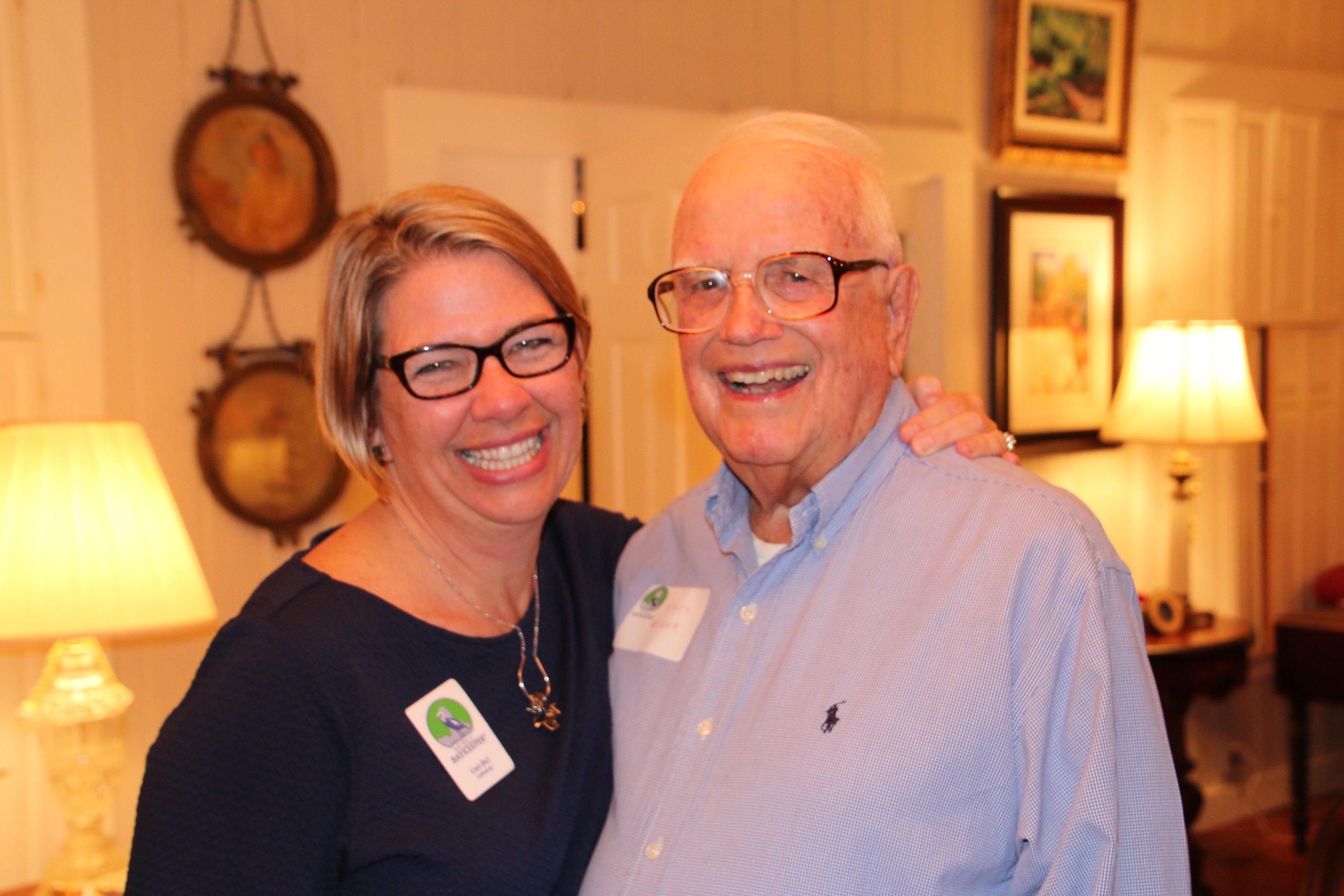 Executive Director Casi (kc) Callaway and Jack Greer exchange a laugh at the 20th Anniversary Kickoff Party in January of 2017 at the Greer's home. 