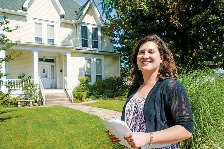 Rachel Silva with the Arkansas Historic Preservation Program pauses in front of the G.L. Cunningham House that will be part of the Walks Through History Tour of the Moose Addition Historic District in Morrilton.