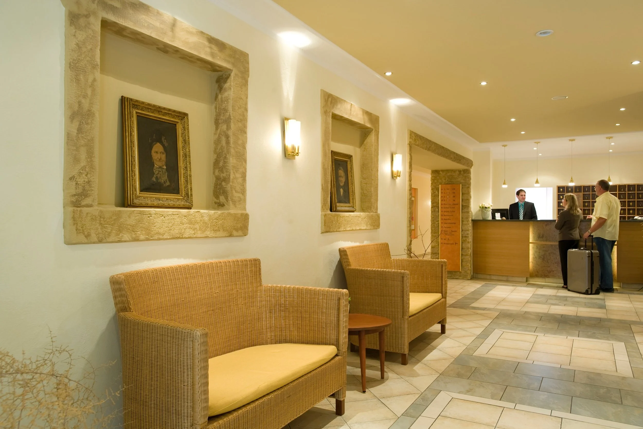 Herzlich Willkommen unser Empfangsbereich mit den Portraits von Magarete M. und Theodor Iding den Namensgebern vom IDINGSHOF Hotel & Restaurant