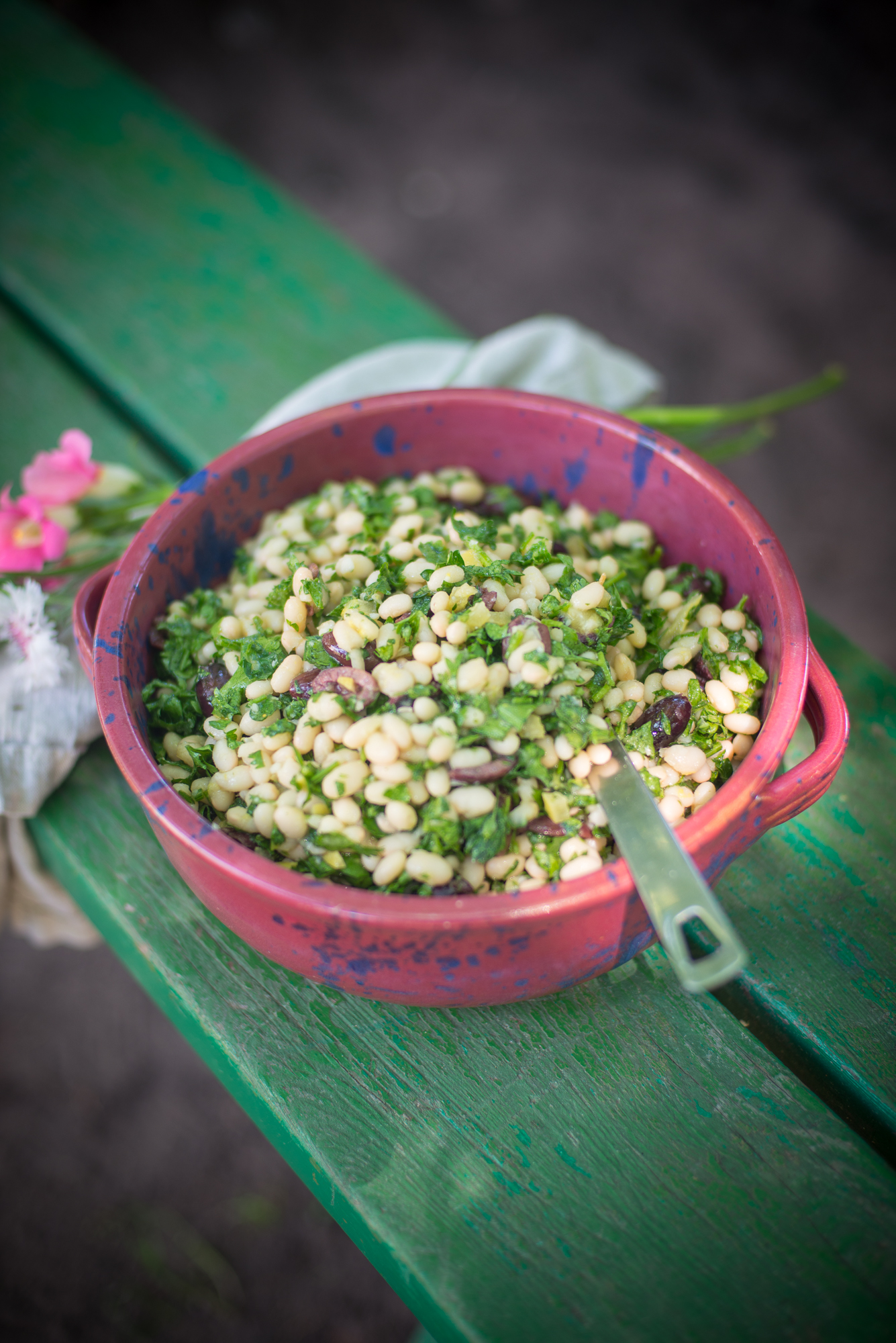 Canelli bean summer salad with olives and fresh herbs. The red bowl comes from Browns Pottery in Arden , North Carolina.