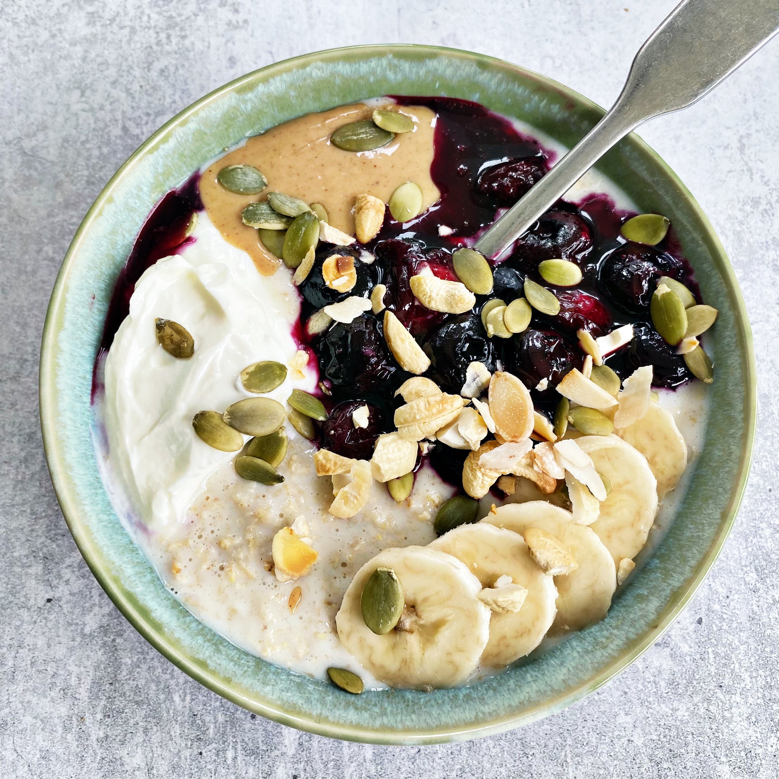  Balanced porridge bowl with nut butter, fruit, seeds and yoghurt 