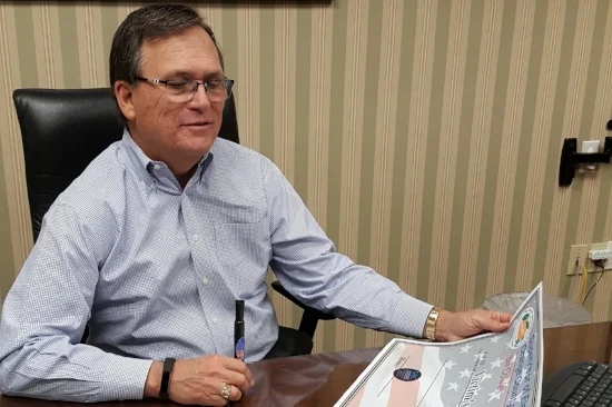 Bill Cowles prepares to sign an oversized Adopt-a-Precinct check. Photo courtesy of the Orange County Supervisor of Elections.