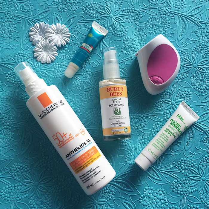 Clockwise From The Top: 1) Garnier Skin Naturals Pure Pimple Control Pen, 2) Neutrogena Wave Original Vibrating Power-Cleanser, 3) Bliss No 'Zit' Sherlock Correcting Serum, 4) Burt's Bees Natural Acne Solutions Daily Moisturizing Lotion, and 5) La Roche Posay Anthelios XL SPF 50+ Spray