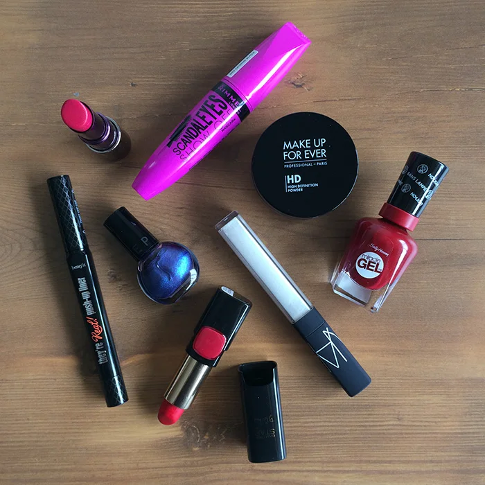 Clockwise From The Bottom: 1) Benefit They're Real! Push-Up Liner, 2) Urban Decay Revolution Lipstick In 'Catfight', 3) Rimmel ScandalEyes Show Off Mascara, 4) Make Up For Ever HD Powder, 5) Sally Hansen Miracle Gel In 'Dig Fig', 6) NARS 'Vent Sale' Lip Gloss, 7) L'Oreal Color Riche Pure Reds Star Collection In 'Pure Scarleto', and 8) Sephora Metallic Nail Polish In 'Deep In Her Eyes'