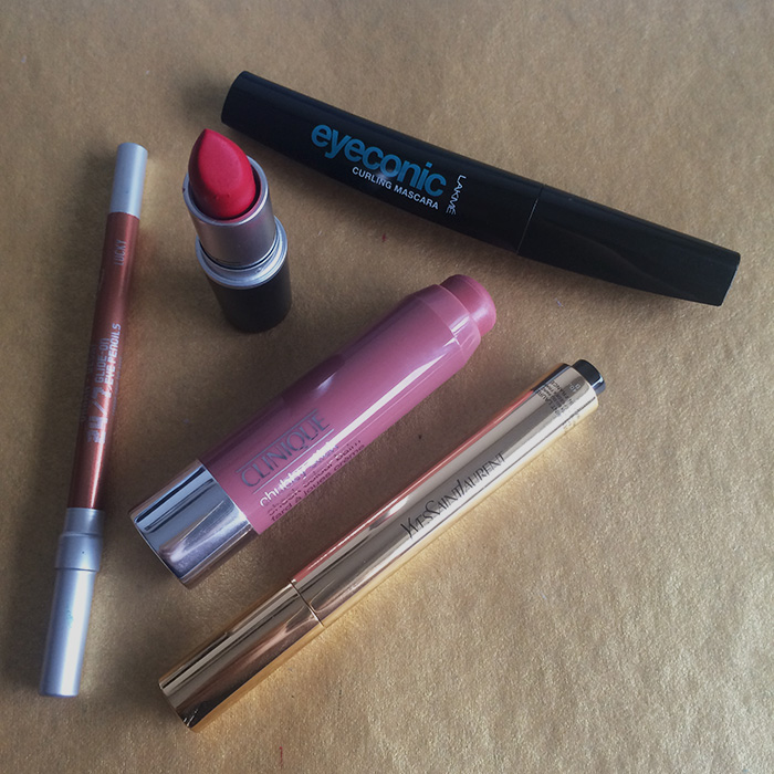From Left To Right: 1) Urban Decay 24/7 Glide-On Pencil In 'Lucky', 2) MAC Lipstick In 'Ruby Woo', 3) Clinique Chubby Stick Cheek Colour Balm In 'Amp'd Up Apple', 4) Yves Saint Laurent Touche Eclat Highlighter, and 5) Lakme Eyeconic Curling Mascara 