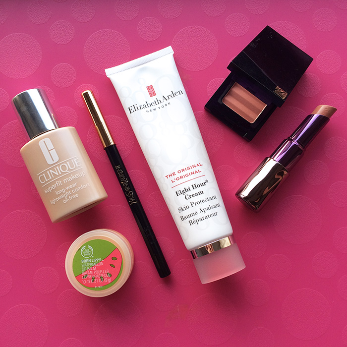From Left To Right: 1) Clinique Superfit Foundation, 2) The Body Shop Born Lippy Pot Lip Balm In 'Watermelon', 3) Yves Saint Laurent Dessin Du Regard Waterproof Eye Pencil In 'Black Ink', 4) Elizabeth Arden Eight Hour Cream, 5) Estee Lauder Tender Blush In 'Nude Rose', and 6) Urban Decay Revolution Lipstick In 'Naked 2'