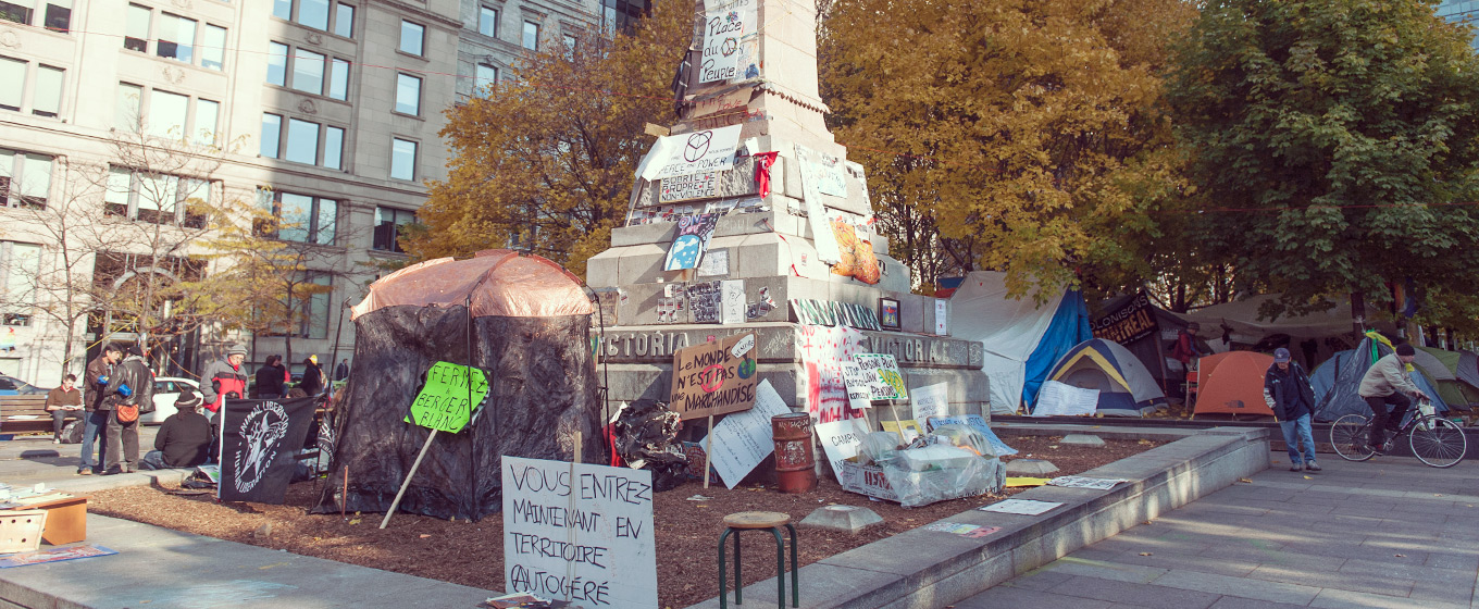 À l’automne 2011, alors que le mouvement Occupons Montréal s'approprie le square Victoria, des pancartes sont installées sur le Monument à la reine Victoria (1869) de Marshall Wood. © Denise Caron