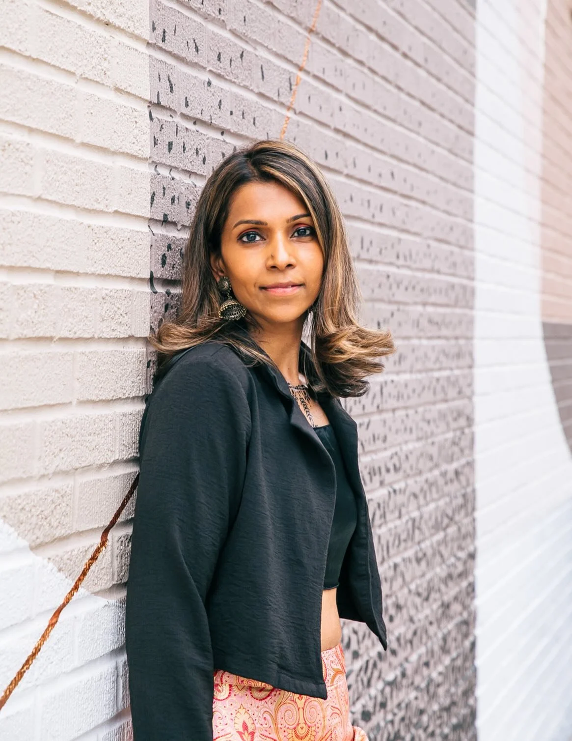 Not every headshot needs a white background. 

This was my second time photographing this talented local female musician. For her latest session, we leaned into lots of color and our amazing local murals were the perfect match to her vibrant style an