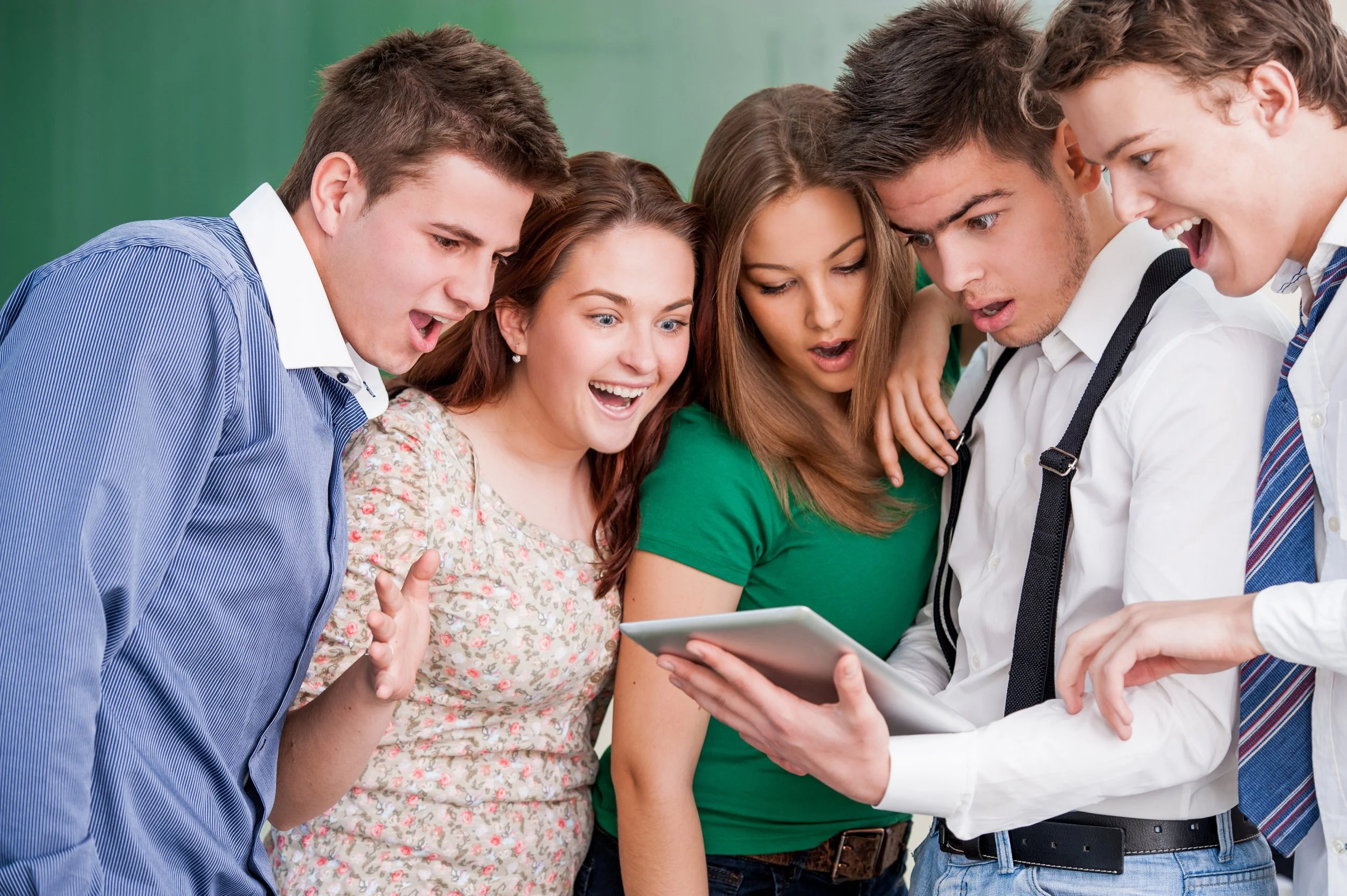 a-group-of-five-students-looking-at-a-tablet-SBI-300996800.jpg