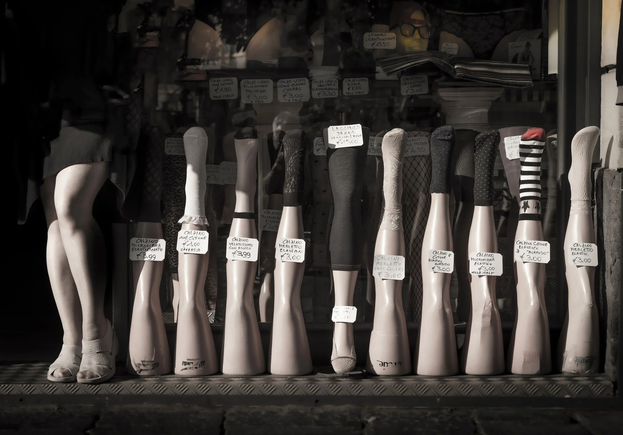 Catania  SHE'S GOT LEGS  A woman poses with manniquins in a street display .jpg
