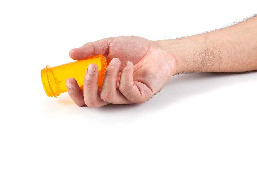 bigstock-Man-s-hand-with-empty-pill-bot-104277830(1).jpg
