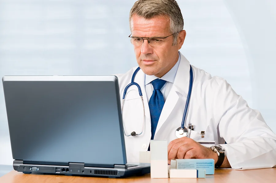 bigstock-Mature-doctor-working-on-lapto-14508200.jpg