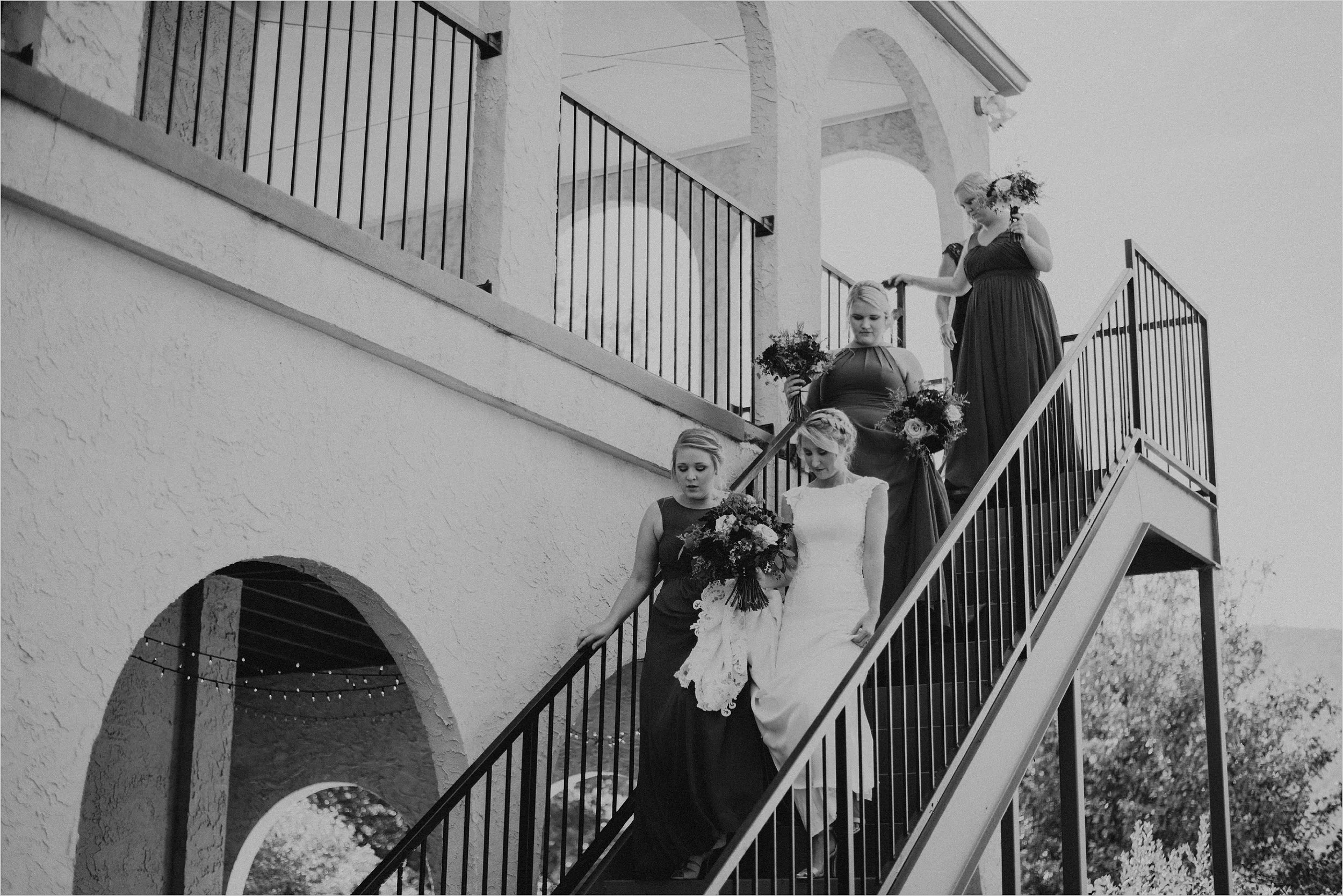 Bride and bridesmaids descend stairs of villa
