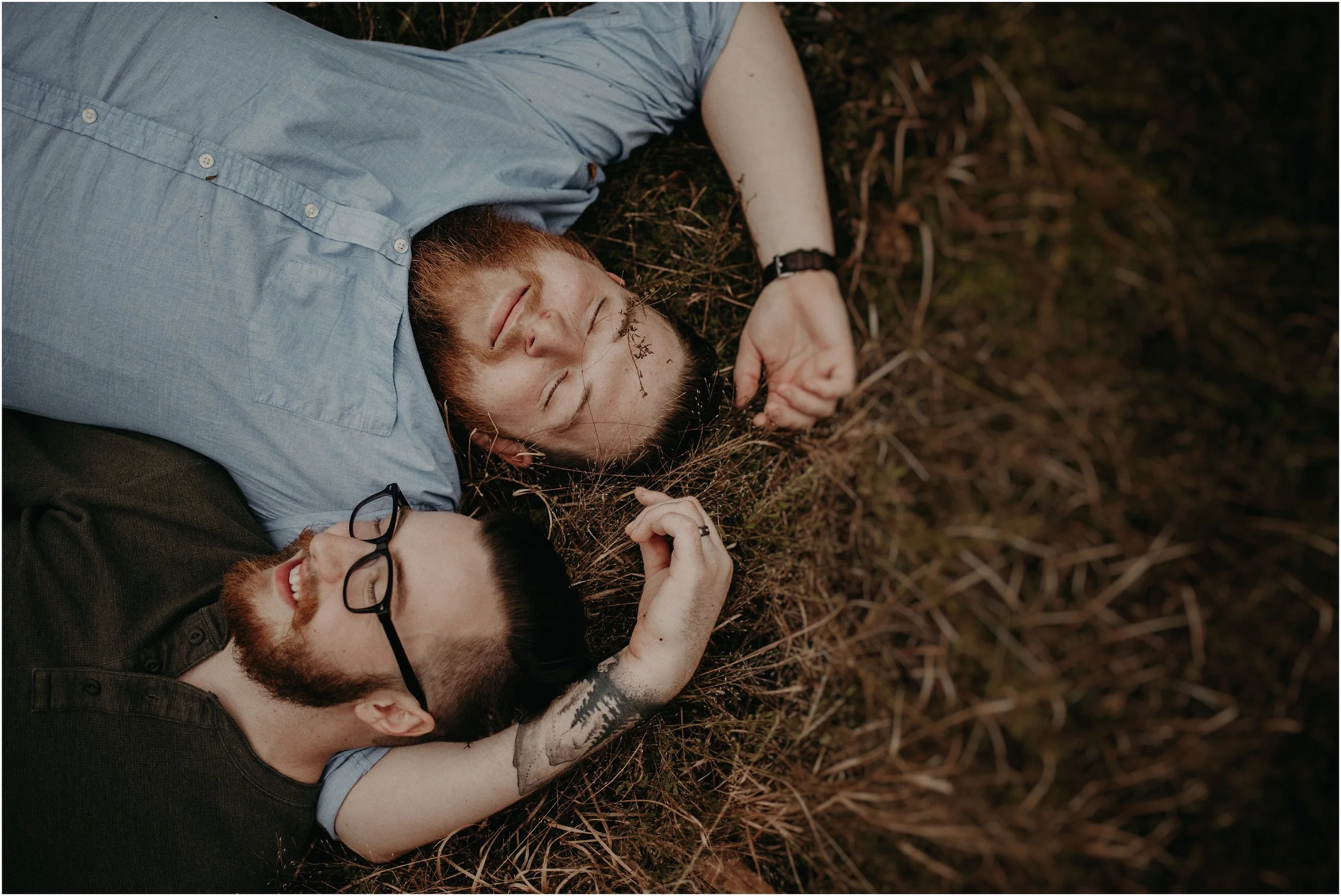 LGBTQ love story photo session with couple laying in field
