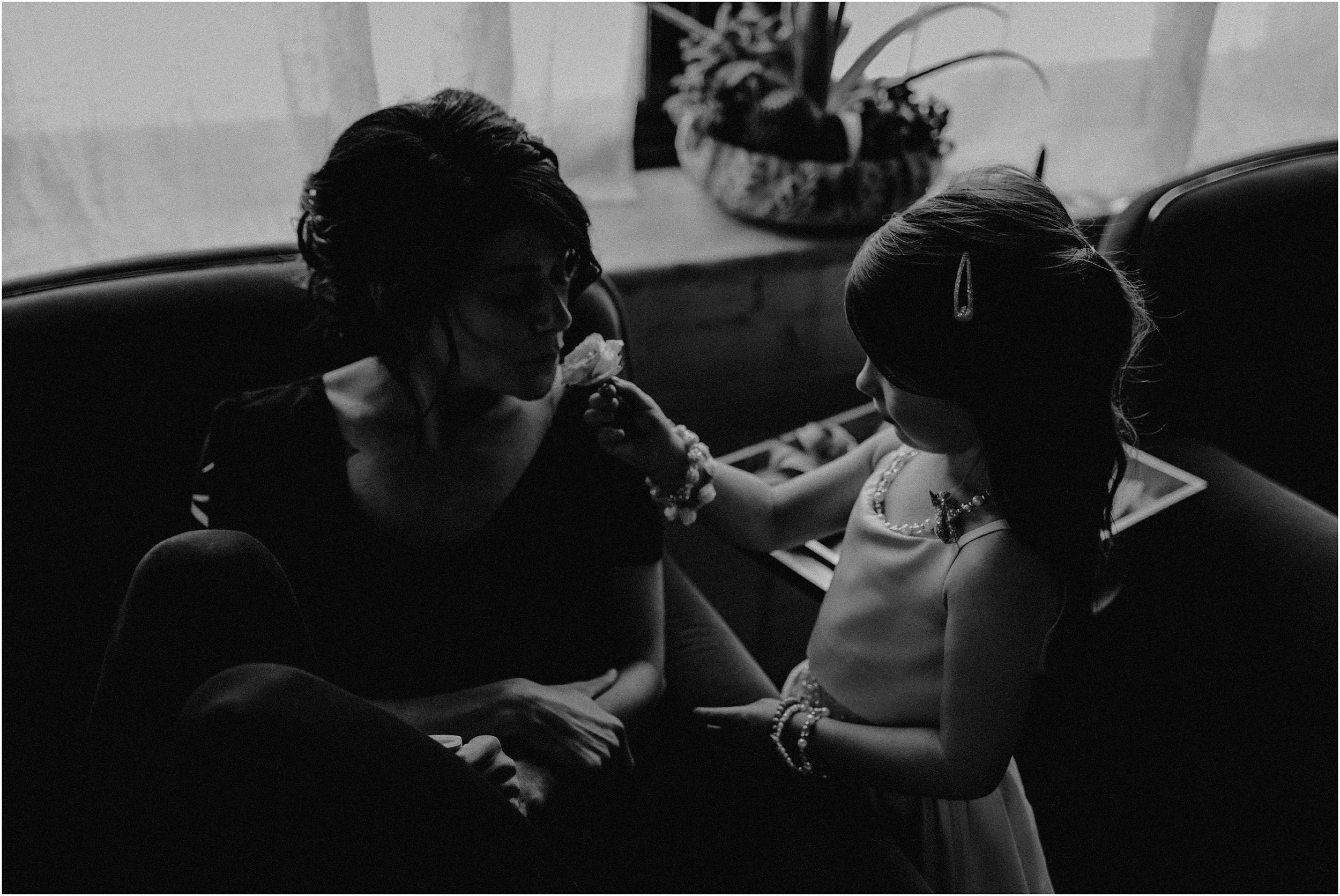 Young daughter gives a flower to her mother, the bride