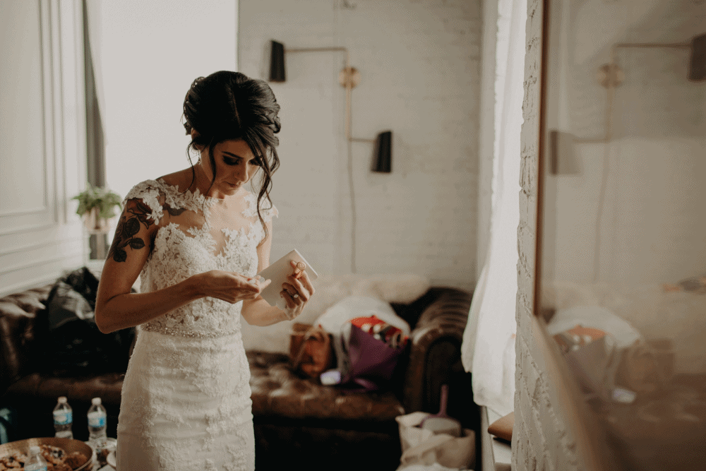 Cheeky bride grabs her Vow book before the wedding ceremony