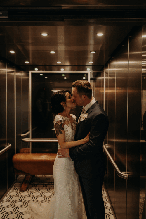 Moving image of the couple embracing behind the closing elevator doors