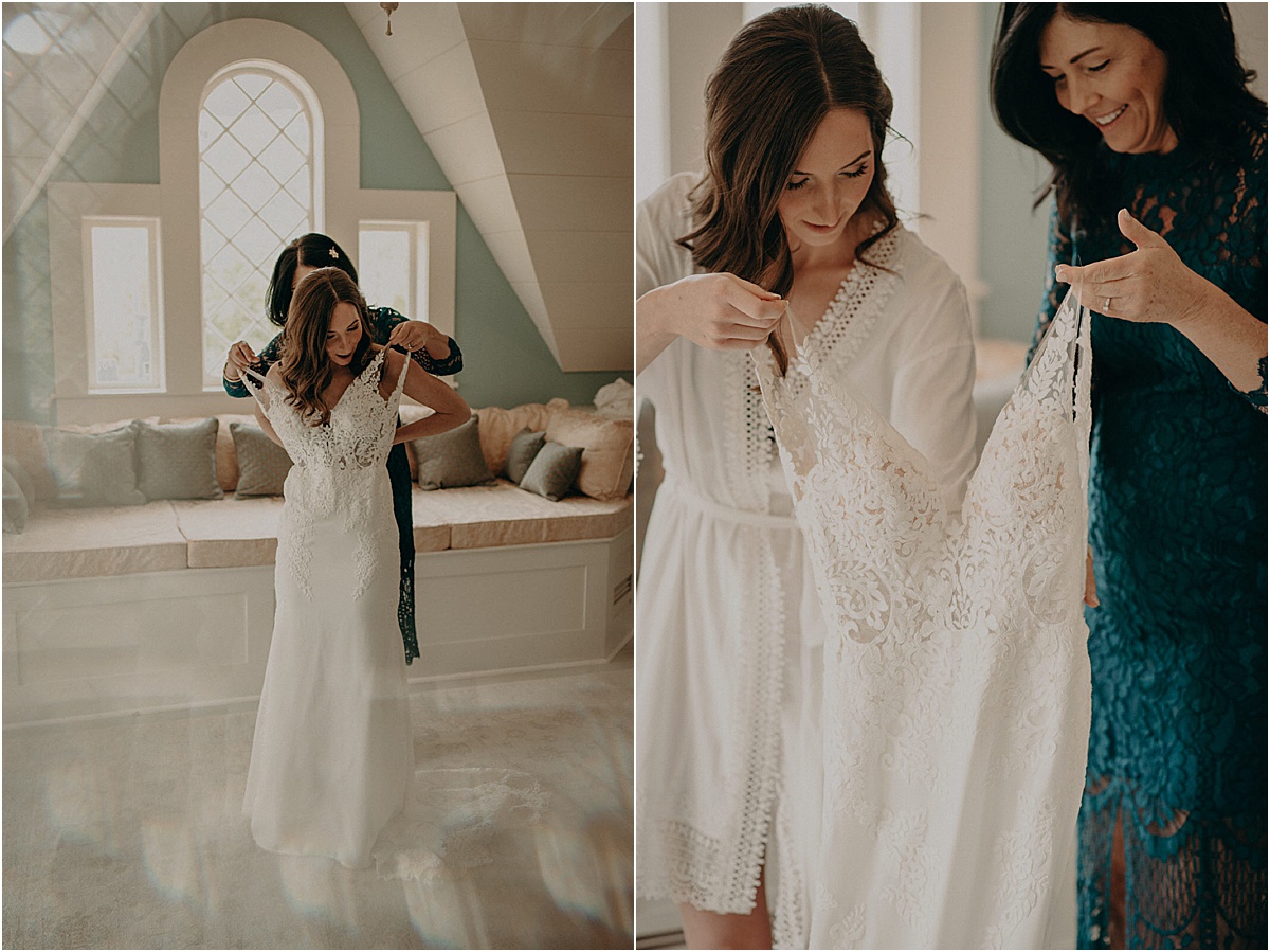 bride and mother putting on white wedding dress