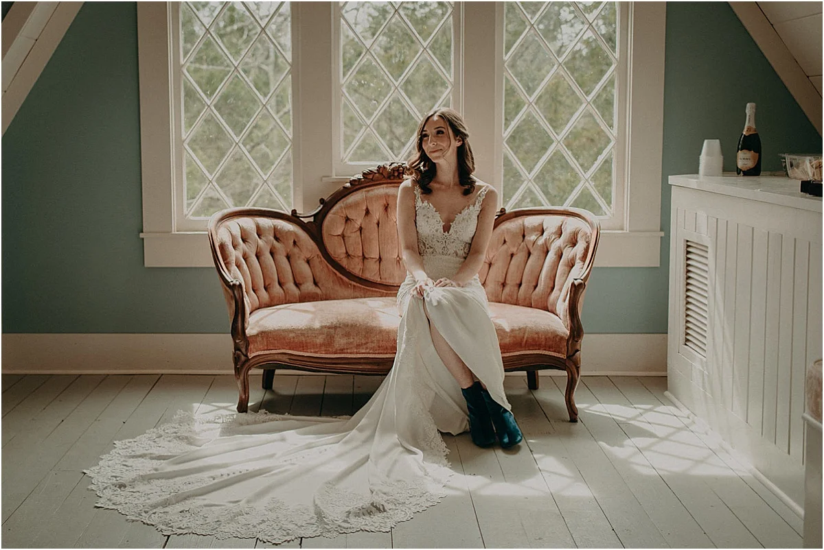 bride in white wedding dress sitting on pink antique couch