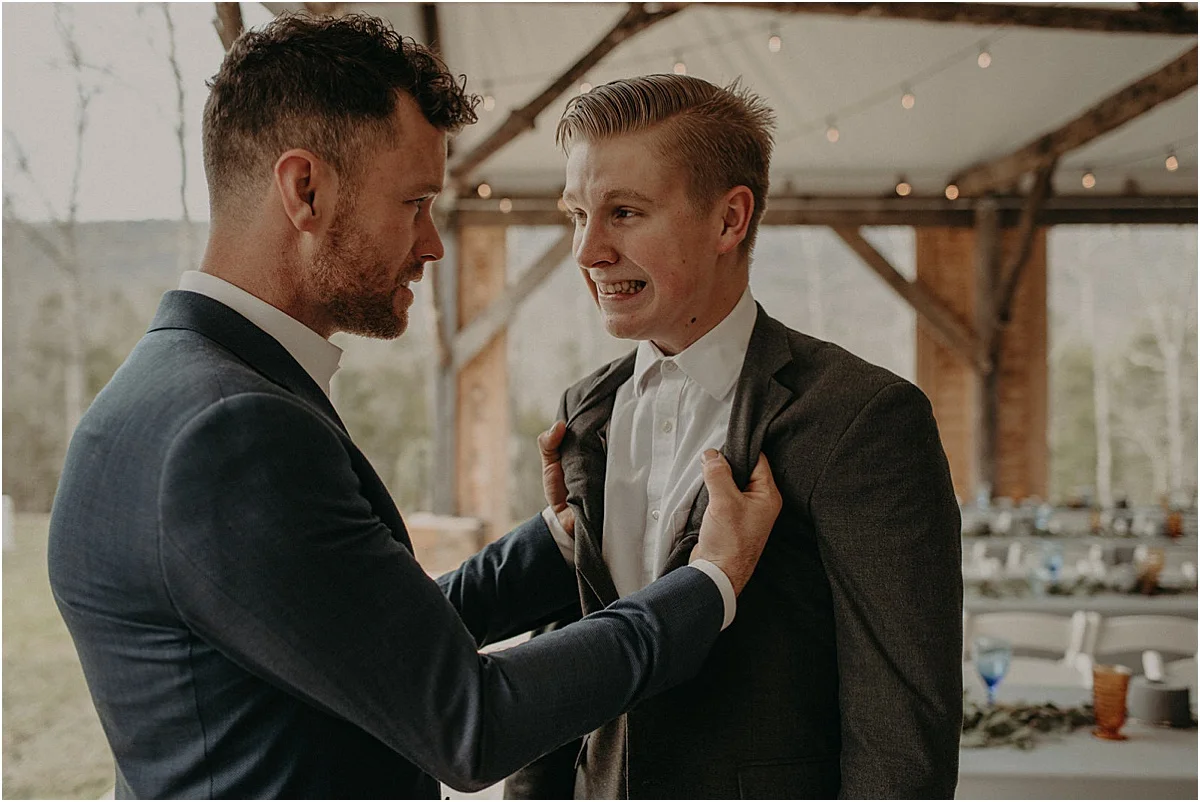 groom grabbing friends suit before wedding ceremony