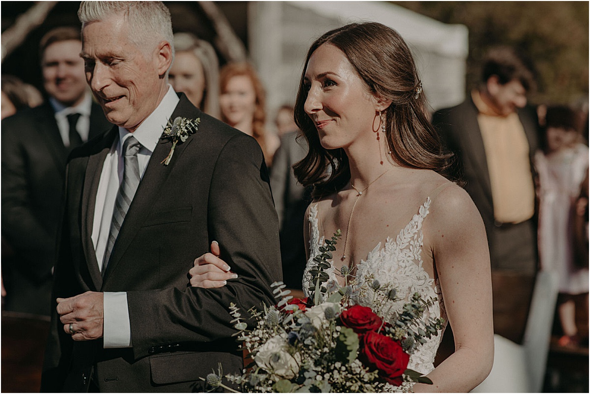 bride walking down the aisle during wedding ceremony with father