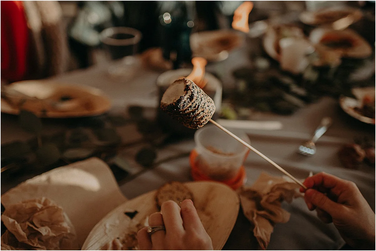 guest holding roasted marshmallow at wedding reception