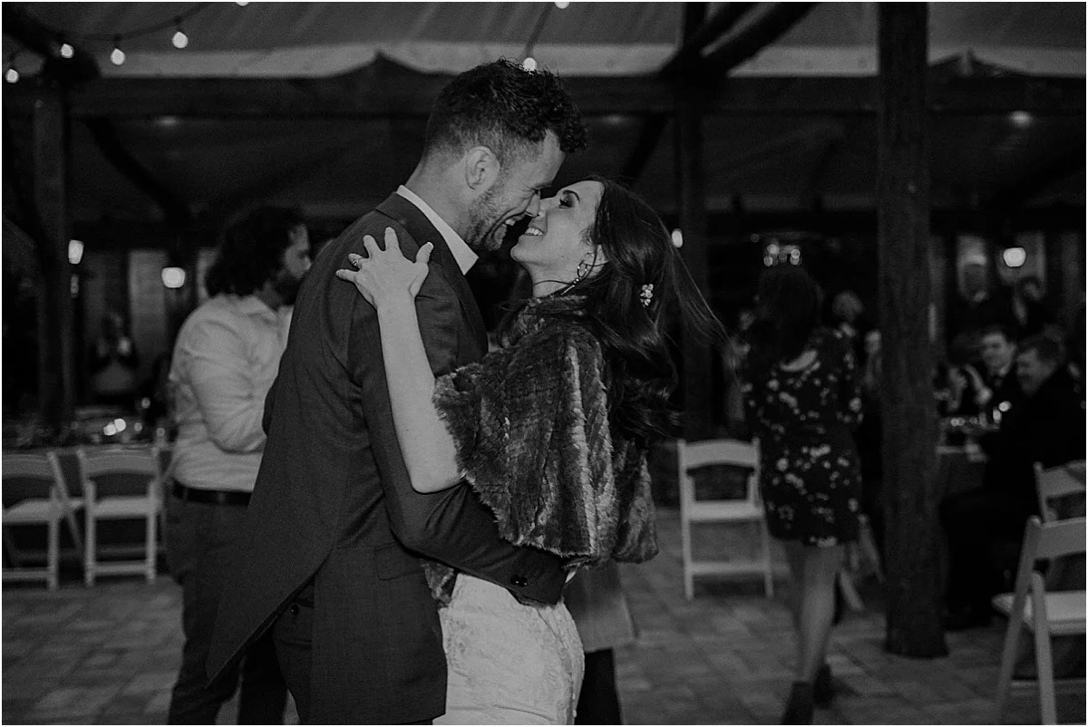 bride and groom smiling and embracing during candlelight ridge wedding reception