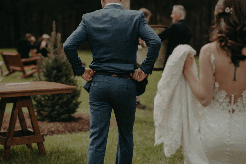 groom walking with bride before ceremony shaking his butt
