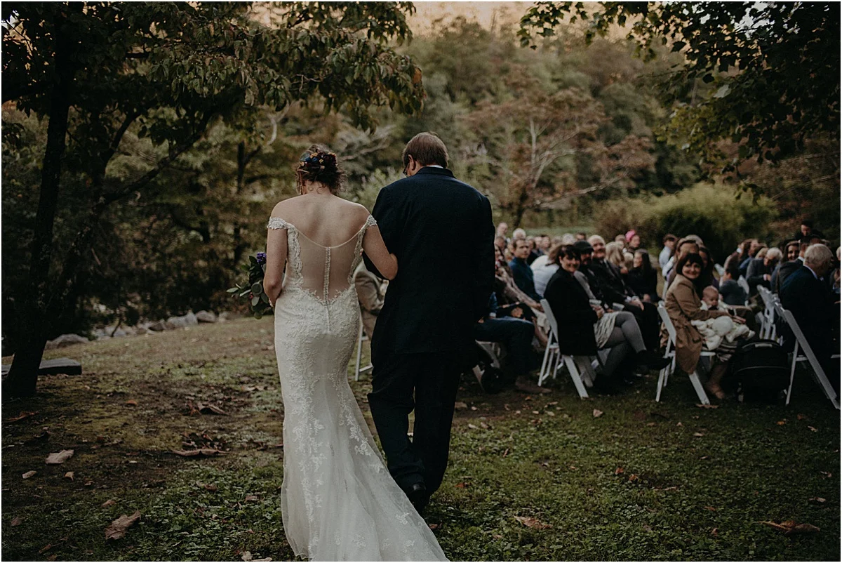 back of bride and father of the bride down aisle