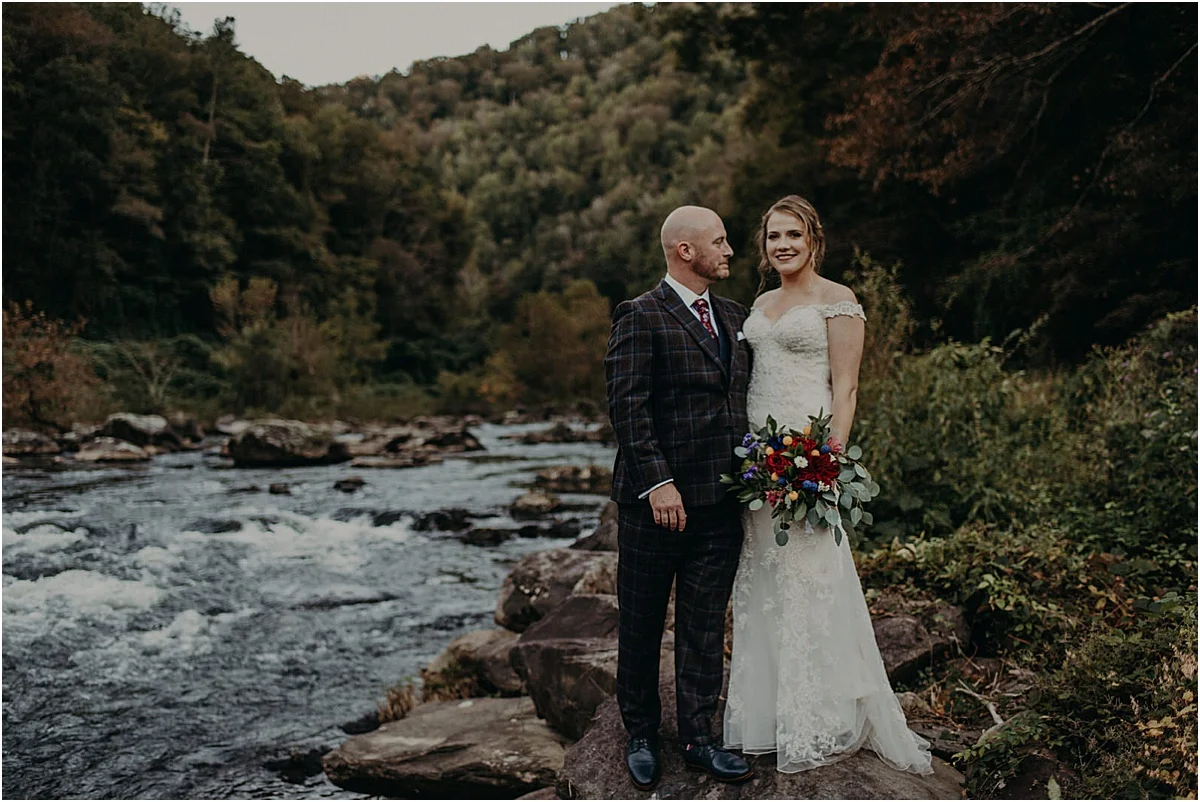 bride and groom in front of river in north carolina