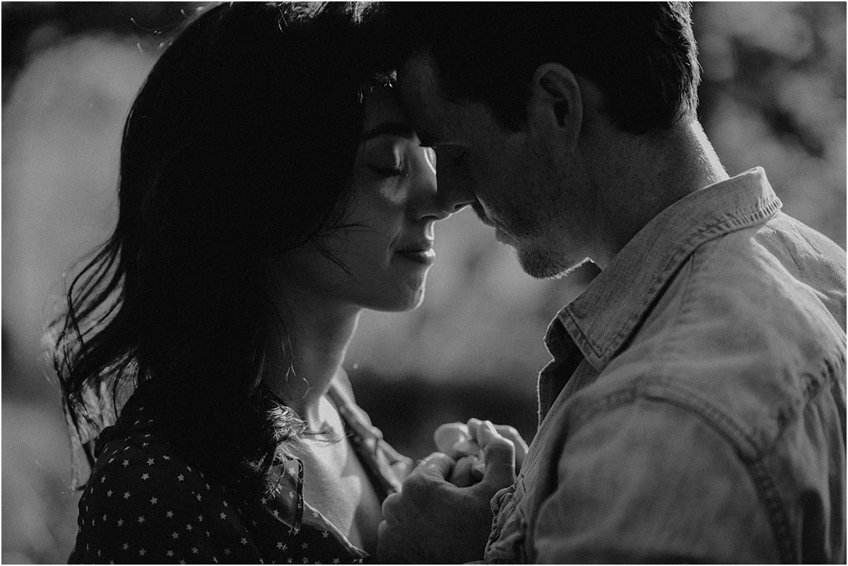 engaged couple putting their heads together and holding hands
