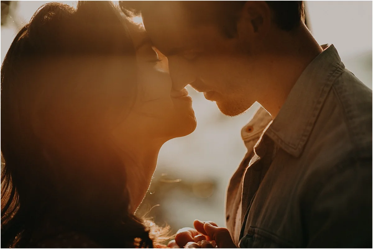 engaged couple putting their heads together and holding hands