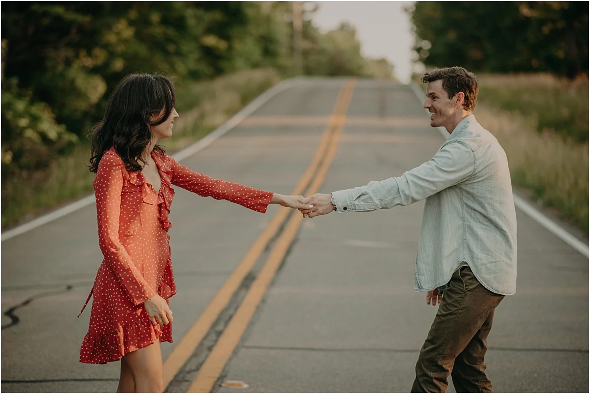 engaged couple holding hands in middle of road