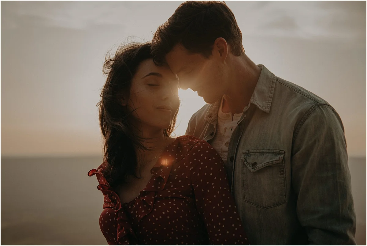engaged couple embracing in the sunlight