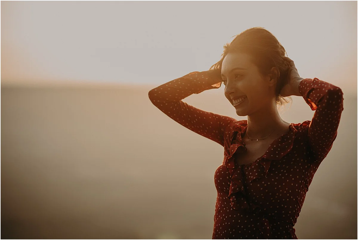 woman holding up her hair in the sunset