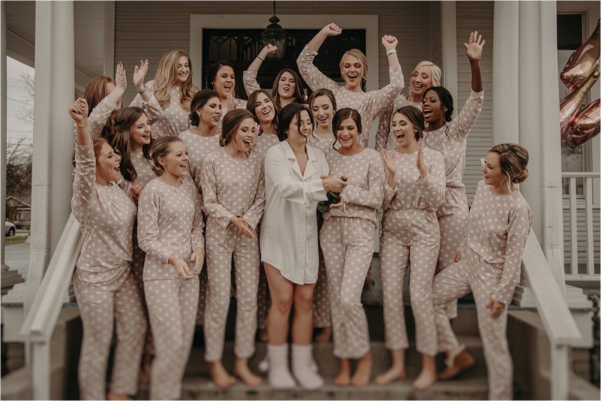 The bride shakes up a champagne bottle on the morning of her wedding