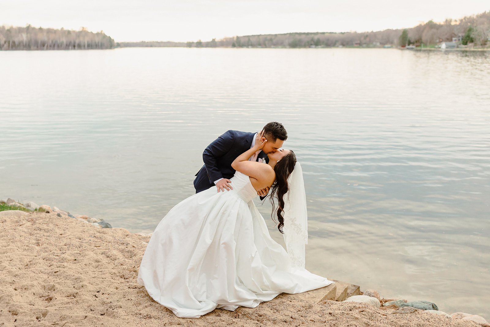 bride and groom kissing by the lake in minnesota
