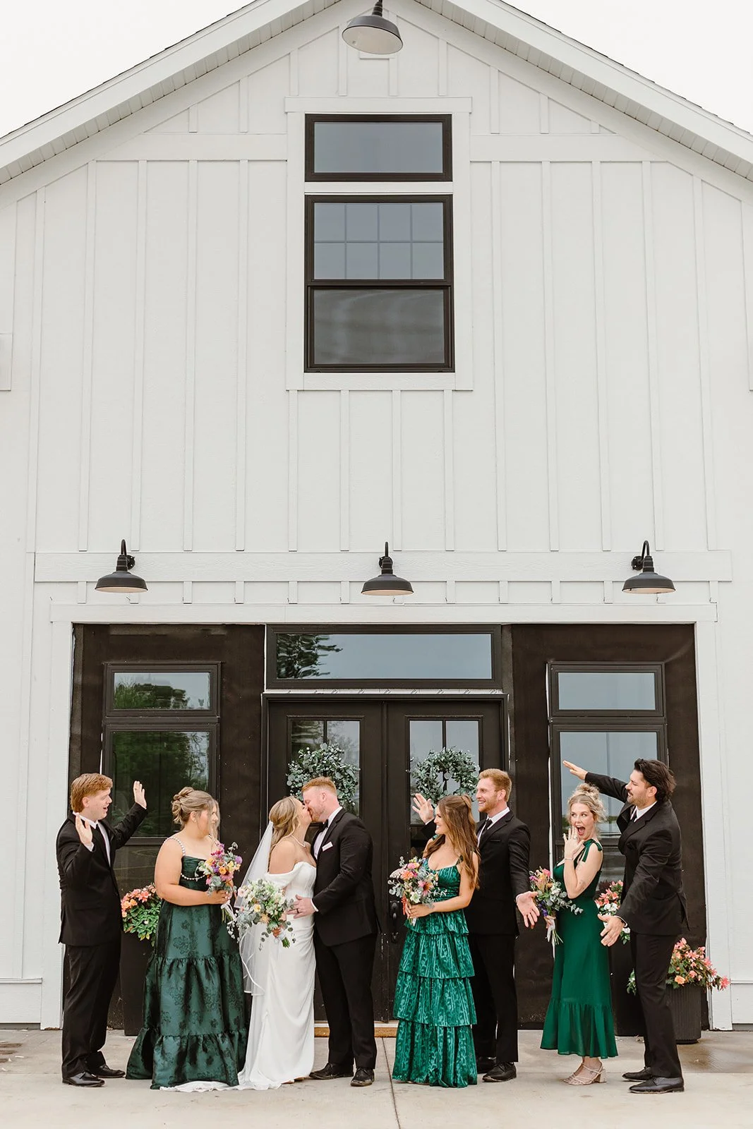 bridal party group celebrating bride and groom kiss