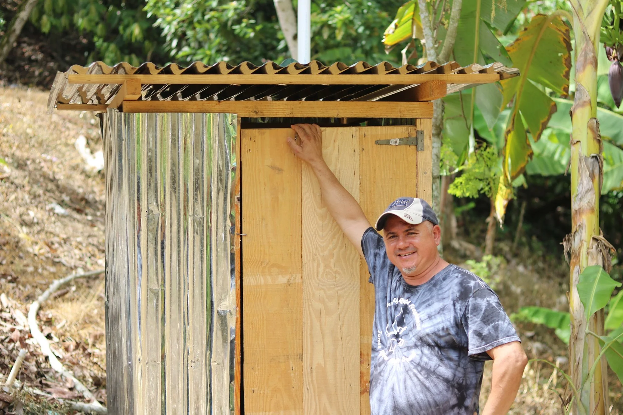 blue-missions-volunteer-posing-next-to-latrine.jpg