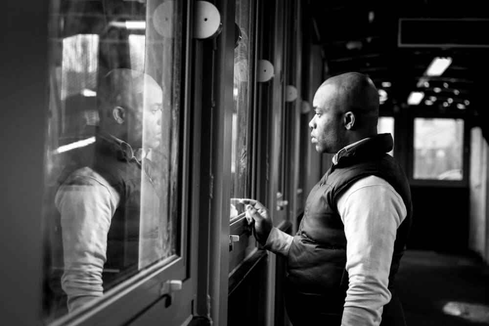 A photograph of man and his reflection in the windows, taken at the Gravesend railway station